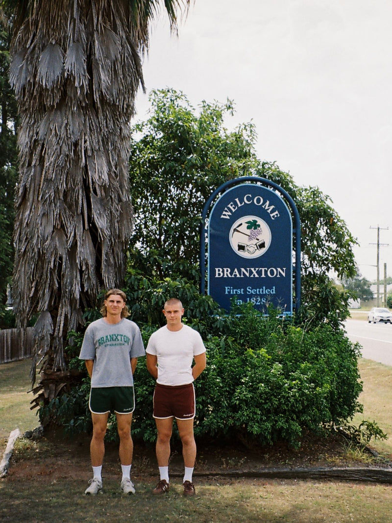 Ethan and Reece standing at the Welcome to Branxton town sign