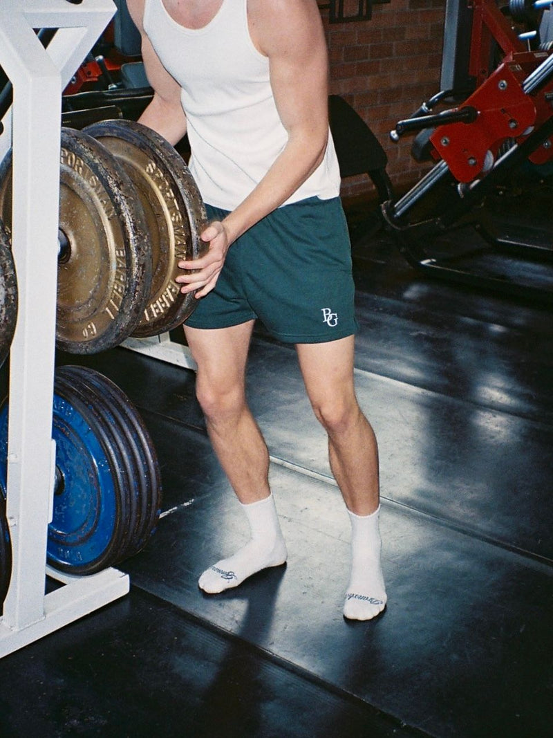 Interior of an old-school gym with vintage benches and a person bench pressing